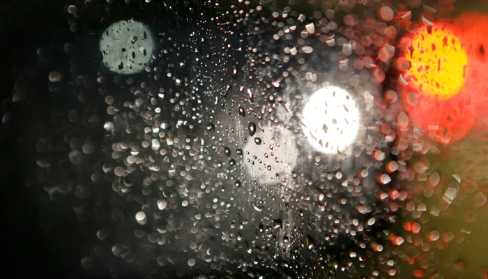 Retrovisor embaçado com muitas gotas de chuva.