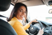 Beneficios do seguro auto para mulheres representado com uma mulher dirigindo.