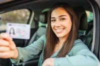 Suspensão da CNH representada por uma mulher com sua CNH na mão.