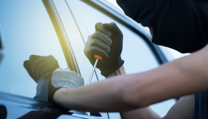 Passo a Passo de Como Acionar o Seguro em Caso de Roubo representado por um carro sendo roubado.