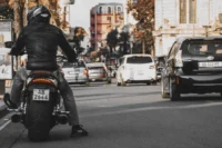 Valor do seguro obrigatório de carro e moto representado por vários carros e uma moto na estrada.