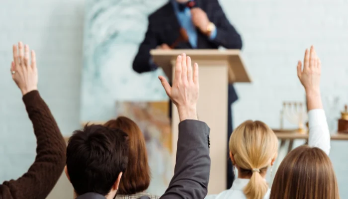 Passo a passo de como comprar carros em leilão online representado por um leilão presencial com pesoas.