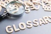 Imagem com uma lupa e ao lado escrito glossário de seguros.