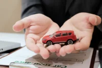 Duas mãos segurando um carrinho representando seguro byd.