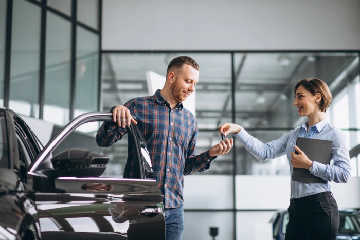 Vendedora explica sobre a garantia do carro a um cliente.
