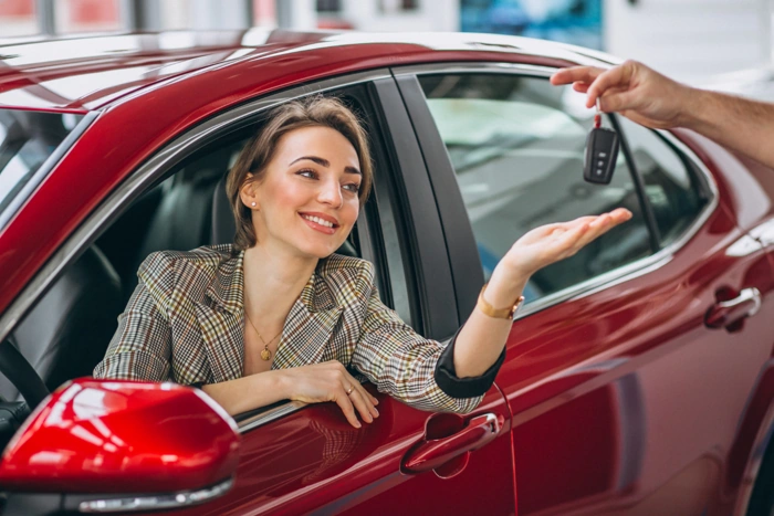 Proprietária pega chaves do seu novo veículo após ouvir sobre garantia do carro.