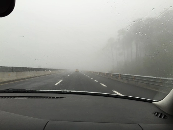 Rodovia cheia de neblina, vista de dentro de veículo. Representa como dirigir com neblina.