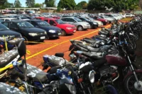 Carros e motos de leilão enfileirado em um pátio. Falando sobre se carro de leilão faz seguro.