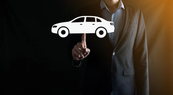 Homem aponta para figura de carro digitalmente incluído na imagem. Falando sobre os carros usados mais seguros do brasil.