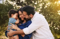 Família feliz se abraçando. Falando sobre motivos para contratar um seguro de vida.