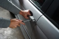 Pessoa tenta arrombar carro com uma chave de fenda. Falando sobre qual a diferença entre roubo e furto de veiculos.