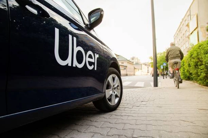 Logomarca do Uber na lateral de um carro preto. Falando sobre se seguro para uber é mais caro.