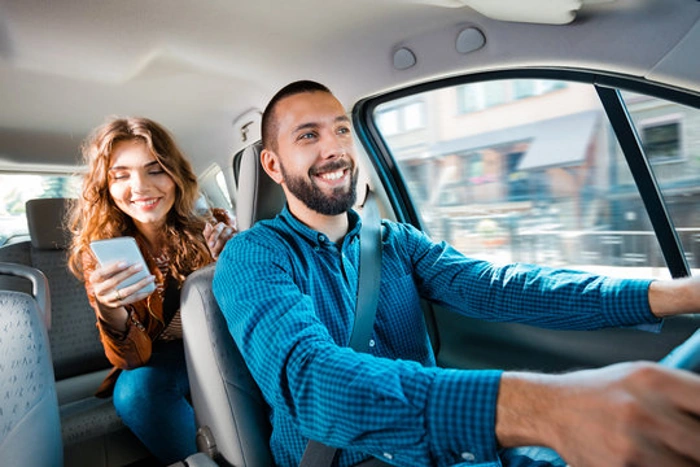 Motorista de Uber e uma passageira dentro de um carro. Falando sobre se seguro para uber é mais caro.