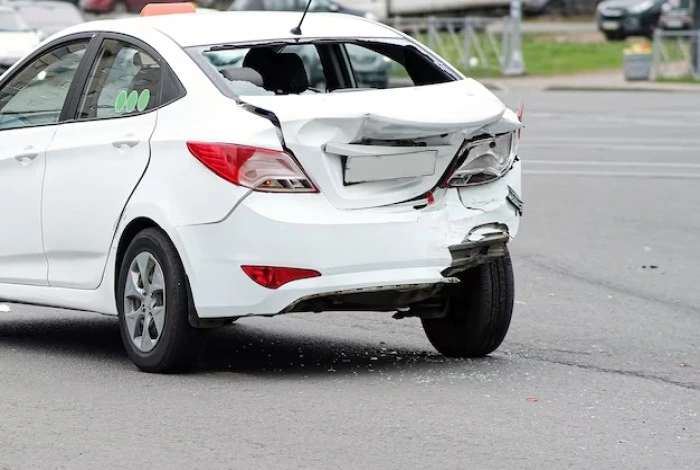 Carro com traseira danificada por uma batida. Falando sobre bati na traseira de um carro o que fazer.