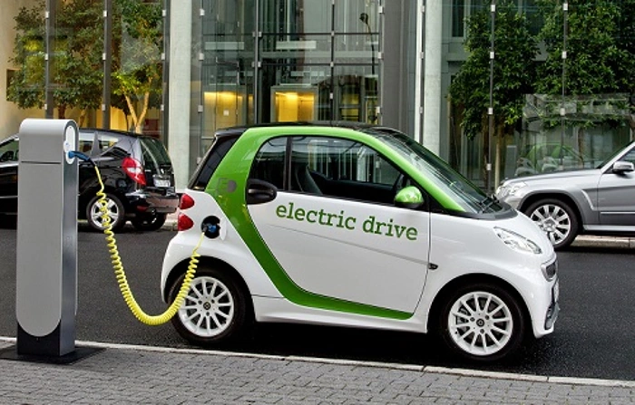 Carro elétrico de pequeno porte estacionado e carregando. Falando sobre seguro de carro elétrico.